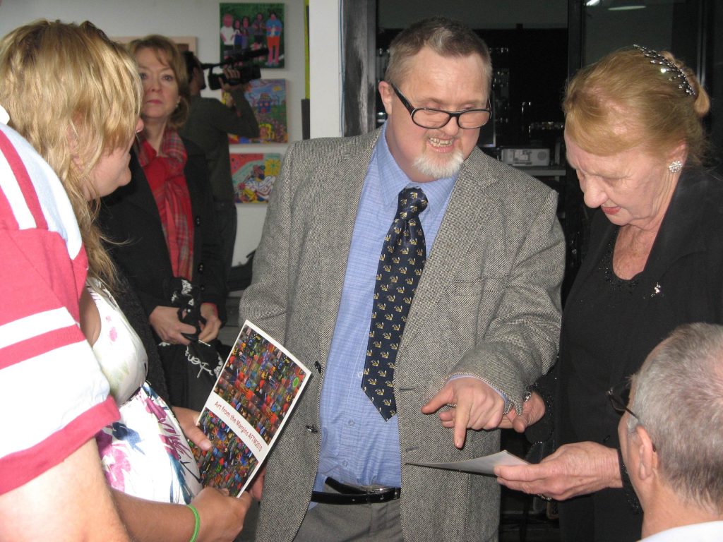 Peter Rowe speaking to fans at an art exhibition